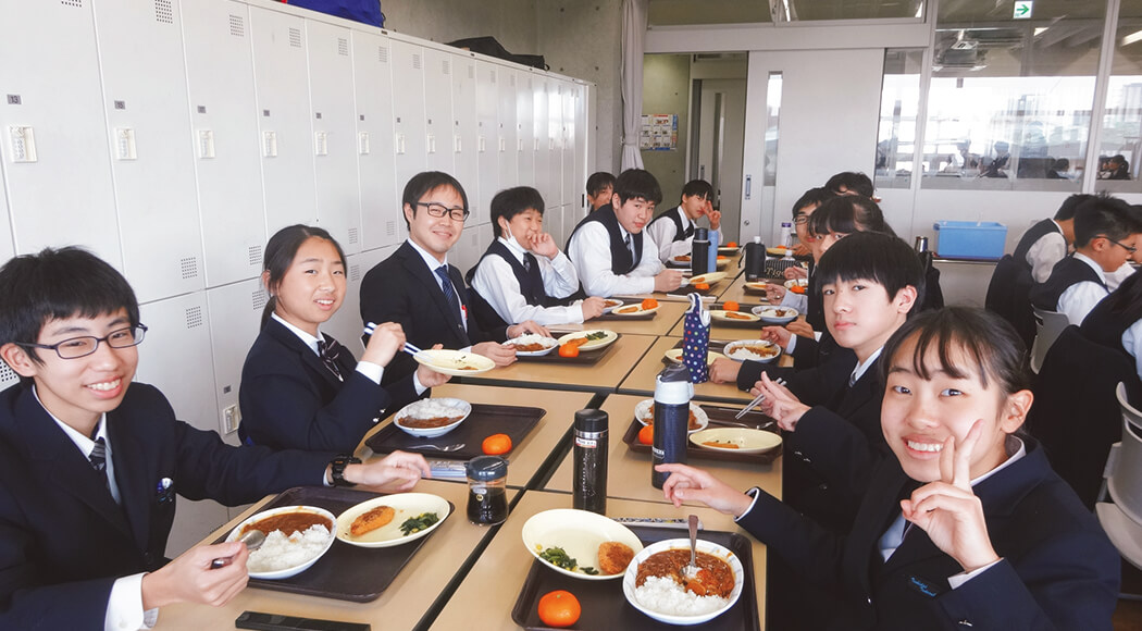 給食を食べる学生と教師